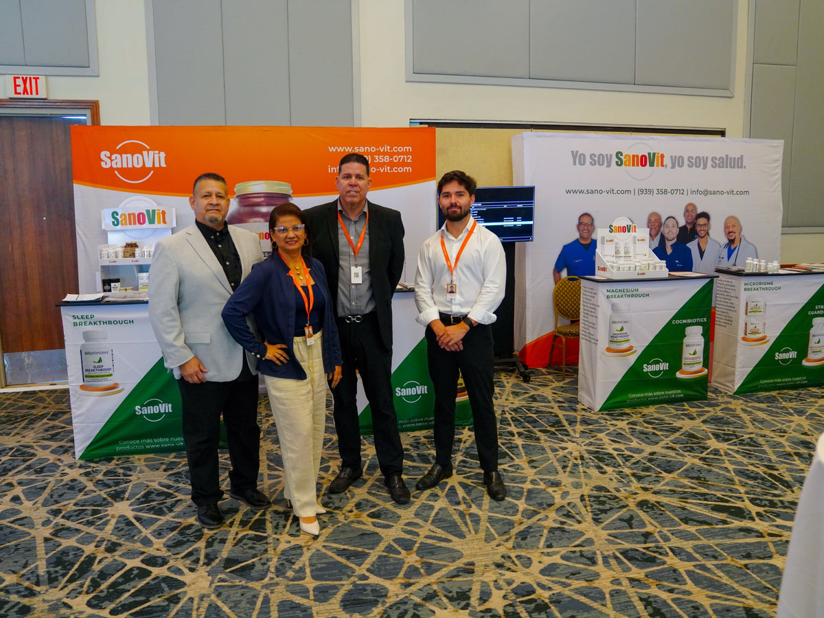 Equipo SanoVit posando junto a su stand en la Academia.