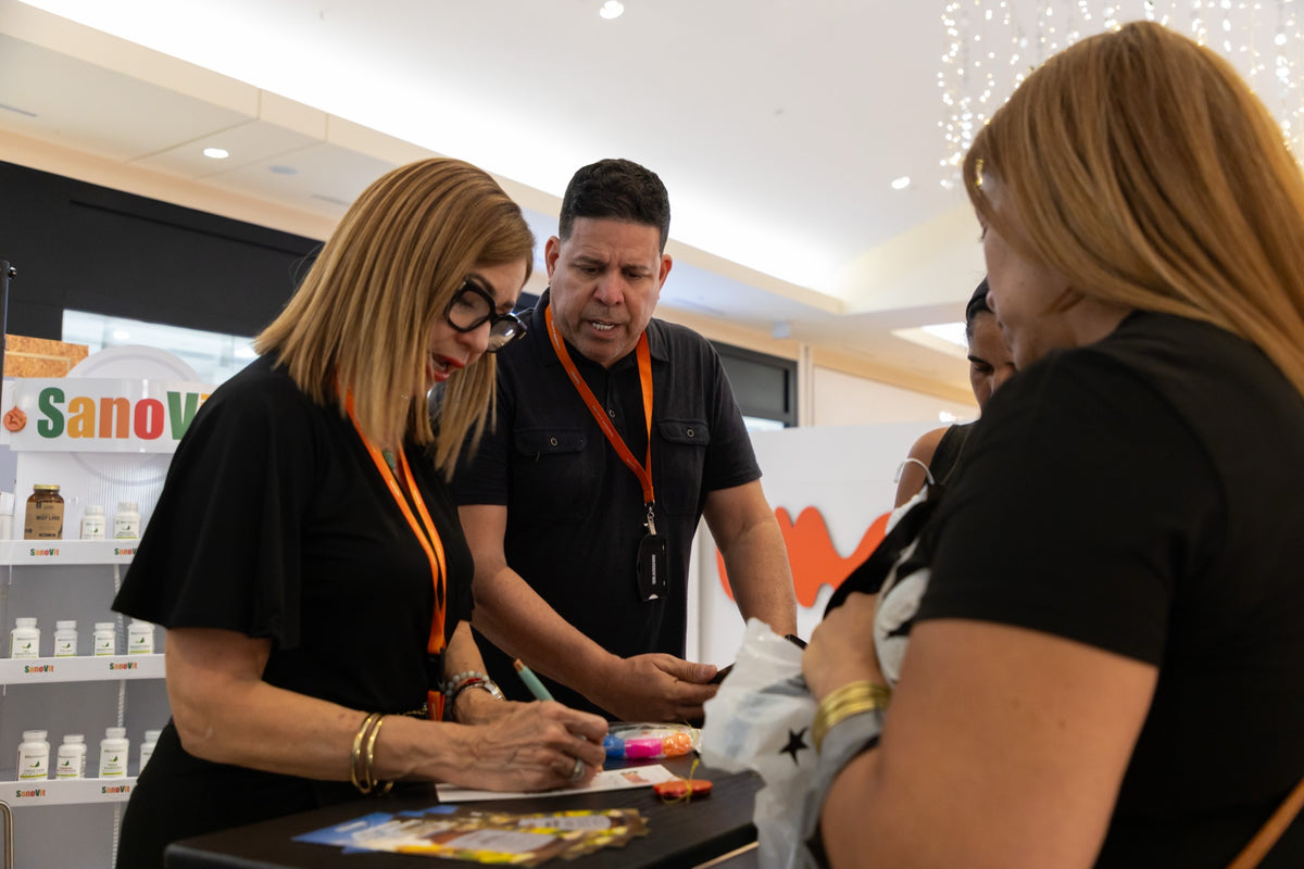 Equipo de SanoVit atendiendo a clientes en su stand navideño.